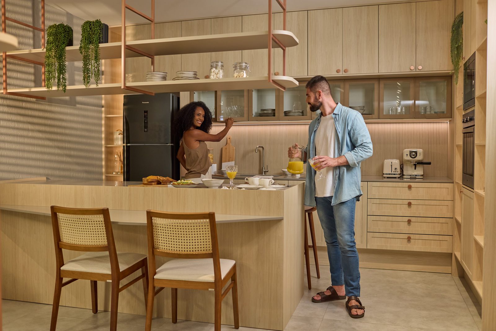 Casal preparando café da manhã em cozinha planejada com ilha central — Italínea By Estilo
